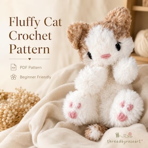 May include: A fluffy, white and light brown crocheted cat plush toy with pink stitched paw pads and nose. The text reads Fluffy Cat Crochet Pattern, PDF Pattern, and Beginner Friendly. The brand name threadbyroseart is printed at the bottom.