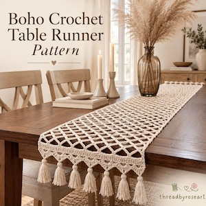 Puede incluir: Un camino de mesa de ganchillo de color crema con un patrón calado en forma de diamante y un fleco decorativo con borlas en el borde. El texto Boho Crochet Table Runner Pattern aparece en la parte superior, con threadbyroseart en la parte inferior.