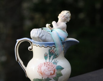 Half doll in a pitcher assemblage