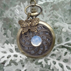 Pocketwatch Mandala with silverblue cabochon in the center and butterfly charm