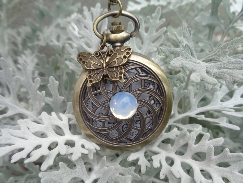 Pocketwatch Mandala with silverblue cabochon in the center and butterfly charm