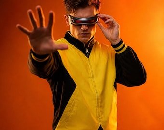 May include: A zip-up jacket featuring a bold yellow front panel contrasted by black sleeves and side panels, paired with a sleek black visor that covers the eyes. The jacket includes a high collar and ribbed cuffs with yellow stripes.