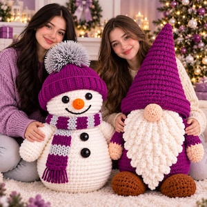May include: A white crocheted snowman with a purple hat, a matching purple and white striped scarf, and black buttons, positioned next to a purple crocheted gnome with a long white beard, a tall purple hat, and brown feet.