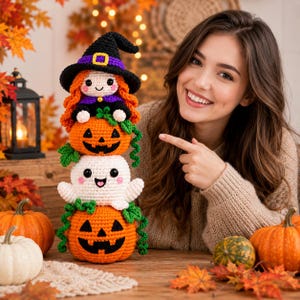 Peut inclure: Une pile verticale de trois figurines crochetées composée d'une sorcière aux cheveux orange avec un chapeau noir, d'une citrouille d'Halloween et d'un fantôme blanc, avec des détails faciaux cousus et des accents de vignes vertes.
