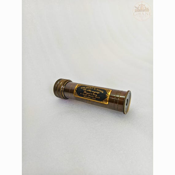 A handcrafted brass kaleidoscope with antique-black finish — the kind of beautiful, tactile desk object that makes visitors immediately pick it up and twist it.