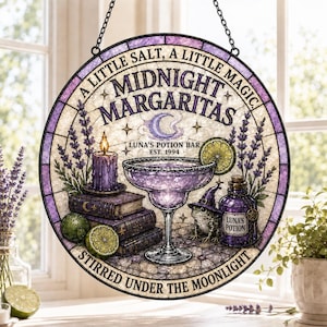 May include: A circular stained glass suncatcher featuring a purple margarita, a frog wearing a witch hat, a stack of books, a candle, and lavender. The text reads: A LITTLE SALT, A LITTLE MAGIC, MIDNIGHT MARGARITAS, LUNA'S POTION BAR EST. 1994, STIRRED UNDER THE MOONLIGHT.