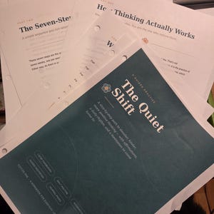 May include: A stack of printed paper documents including a teal cover page titled The Quiet Shift, A Guided Practice, with subheadings for a step-by-step path, affirmations, and daily rhythm, alongside pages titled How Thinking Actually Works.