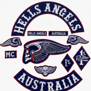 May include: A collection of embroidered patches featuring a large arched HELLS ANGELS top rocker, an AUSTRALIA bottom rocker, a central winged skull emblem, two smaller winged skull patches, an MC patch, and two diamond-shaped 1% patches.