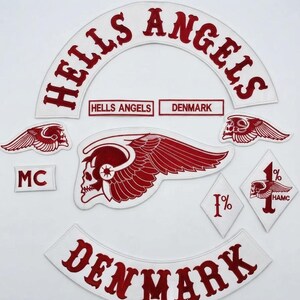 Può includere: Una collezione di toppe ricamate con una grande toppa bianca ad arco con testo rosso HELLS ANGELS, un arco DENMARK abbinato, due piccole toppe con teschio alato, due toppe a forma di diamante 1% e una toppa rettangolare MC.