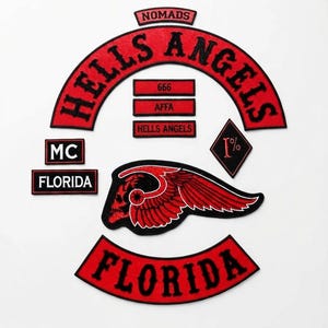 May include: A collection of embroidered patches featuring a large red and black Hells Angels rocker, a Nomads tab, a Florida rocker, an MC patch, a 1% diamond patch, a winged skull emblem, and three rectangular bars with the text 666, AFFA, and Hells Angels.