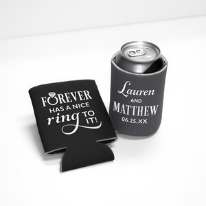May include: Black and gray can coolers with white text. One cooler reads "FOREVER HAS A NICE ring TO IT!" with a diamond ring graphic. The other cooler has the names "Lauren and MATTHEW" and the date "06.25.XX".