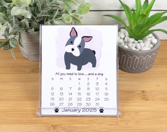 May include: A desktop calendar featuring a cartoon illustration of a French Bulldog. The calendar is for January 2025 and has the text "All you need is love...and a dog".