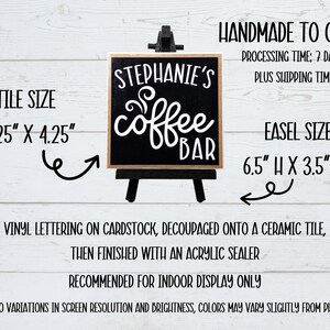 May include: A black and white ceramic tile sign with the text "Stephanie's Coffee Bar" on a small wooden easel. The tile measures 4.25 inches by 4.25 inches and the easel is 6.5 inches high by 3.5 inches wide.