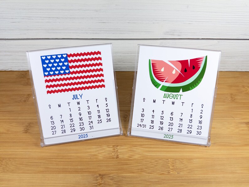 May include: Two small desk calendars with a white background. The July calendar features a red, white, and blue American flag with white hearts. The August calendar features a green watermelon slice with red flesh and black seeds. Both calendars have the year 2025 printed at the bottom.