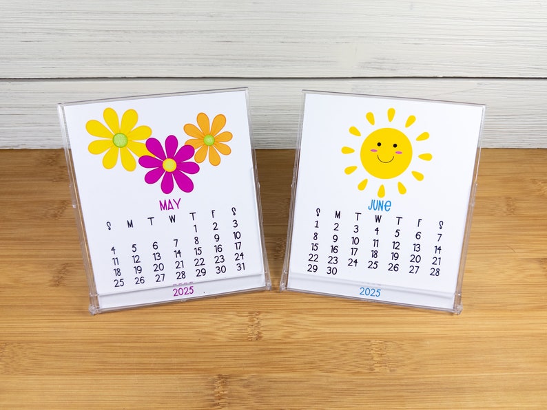 May include: Two small desktop calendars with a floral design for May and a sun design for June. The calendars are both for the year 2025.
