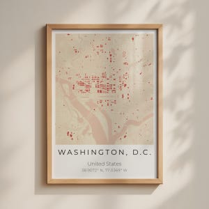 May include: A framed map print of Washington, D.C. featuring a beige background with red building footprints and a river. The text reads WASHINGTON, D.C., United States, and the coordinates 38.9072° N, 77.0369° W in a clean, sans-serif font.
