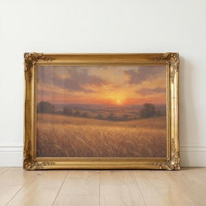 Könnte beinhalten: Ein rechteckiges Landschaftsgemälde in einem verzierten Goldrahmen. Das Kunstwerk zeigt ein goldenes Weizenfeld unter einem Sonnenuntergangshimmel mit orangefarbenen und violetten Wolken, sanften Hügeln und vereinzelten Bäumen am Horizont.