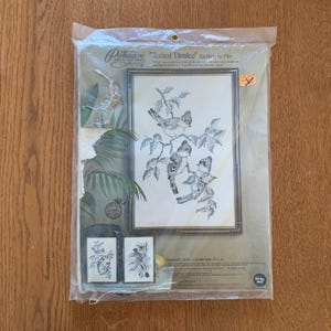 May include: A vintage Paragon "Tufted Tumlee" embroidery kit in a clear plastic package. The kit includes a framed image of birds on a branch, and two smaller images. The frame size is 12" x 16".