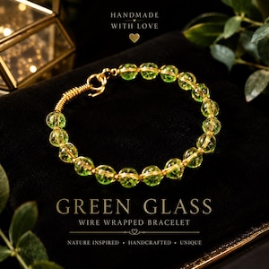 May include: A bracelet featuring round, translucent green glass beads strung on gold-colored wire. The wire is wrapped around the beads and forms a hook-and-eye clasp. The text "HANDMADE WITH LOVE", "GREEN GLASS", and "WIRE WRAPPED BRACELET" is visible.