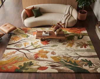 May include: A rectangular area rug featuring a textured, multi-layered design of autumn leaves and tree branches in shades of orange, yellow, olive green, and brown against a cream-colored background, with a raised, carved pile construction.