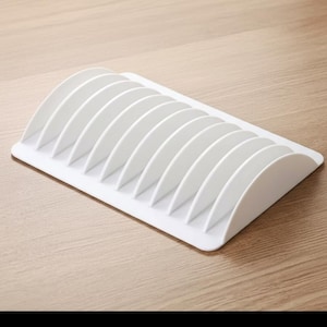 May include: A white rectangular organiser tray featuring a series of evenly spaced, curved vertical dividers. The structure is made of a solid, smooth material and is designed with a flat base that supports the upright, semi-circular partitions.