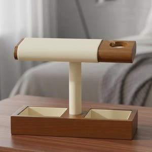 May include: A wooden watch and jewelry stand featuring a horizontal bar with a cream-colored padded top and a circular cutout on the right side. The base includes two square recessed compartments with cream-colored linings and a central support pillar.