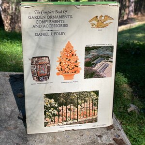 Puede incluir: La contraportada de un libro titulado "The Complete Book of Garden Ornaments, Complements, and Accessories" de Daniel J. Foley. La portada presenta im&aacute;genes de varios ornamentos de jard&iacute;n, incluyendo un asiento de jard&iacute;n de porcelana china, una placa de pared de terracota, un banco de jard&iacute;n de hierro forjado o un conjunto de asientos, y una valla de hierro forjado en una pared de ladrillo.