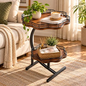 May include: A two-tier side table with a black metal frame and two flower-shaped wooden shelves featuring raised wire edges. The top shelf holds a white ribbed planter with a trailing green plant, a white mug, and a book titled The Kinfolk Home.