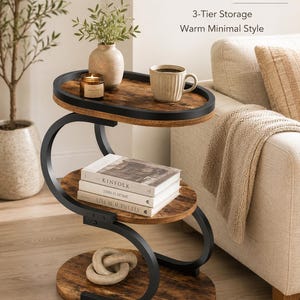 May include: A three-tier side table with an S-shaped black metal frame and three oval wooden shelves featuring a dark brown wood grain finish. The text "Rustic Side Table 3-Tier Storage Warm Minimal Style" is visible in the upper right corner.