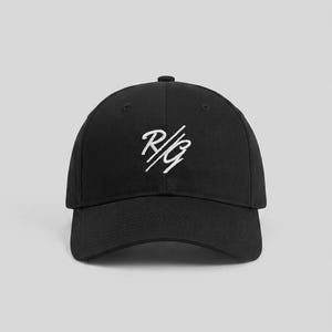 Op de afbeelding: Een zwarte baseballpet met een wit geborduurd logo op het voorpaneel. Het logo bestaat uit de letters R en G gescheiden door een schuine streep in een gestileerd handschriftlettertype. De pet heeft een gestructureerde kroon en een gebogen klep.