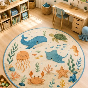 Puede incluir: Una alfombra redonda con fondo beige que presenta una colorida escena submarina. El diseño incluye una ballena azul, una tortuga marina verde, una raya azul, una medusa naranja, un cangrejo, una estrella de mar, un caballito de mar y plantas.