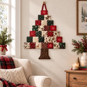 May include: A wall-hanging Christmas tree decoration constructed from quilted fabric squares in red, green, and cream colors. The squares feature patterns of poinsettias, snowflakes, holly, and a deer. A brown fabric trunk is attached at the base.