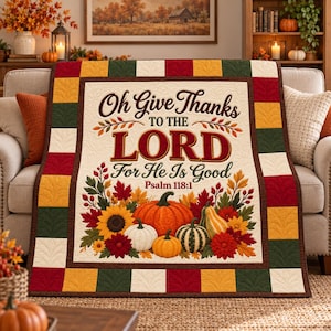 May include: A quilt featuring the text Oh Give Thanks TO THE LORD For He Is Good Psalm 118:1, decorated with illustrations of pumpkins, sunflowers, and autumn leaves. The border consists of a patchwork pattern in red, green, yellow, and white.