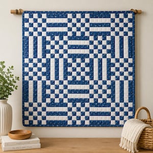 May include: A square wall hanging quilt featuring a geometric checkerboard pattern in navy blue and white. The fabric displays a subtle floral print within the blue squares. The quilt is suspended from a wooden rod mounted horizontally.