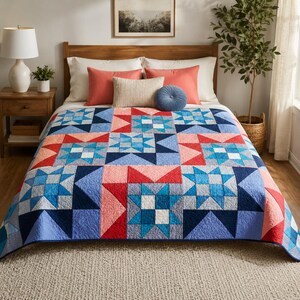 May include: A quilt featuring a geometric star pattern in shades of navy blue, light blue, white, and coral red. The bedspread displays a repeating block design with stitched textures, covering a bed with coral, cream, and blue decorative pillows.
