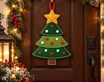 Könnte beinhalten: Ein Weihnachtsbaum-Wandbehang aus Filz mit drei grünen, geschichteten Ebenen, einem gelben Stern als Spitze und einem braunen Stamm. Der Baum ist mit kleinen roten und weißen kreisförmigen Akzenten sowie weißen Ziernähten versehen und an einer roten Schlaufe aufgehängt.