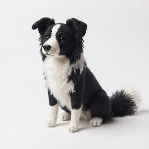 May include: A crocheted stuffed animal in the likeness of a Border Collie dog. The figure features black and white yarn, with a white blaze on the face, a white chest, and white paws. It has dark eyes, a black nose, and a fluffy, textured tail.