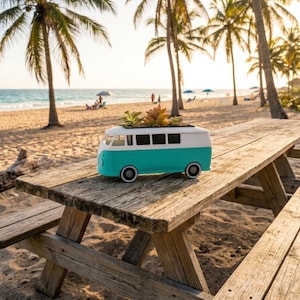 May include: A teal and white camper van shaped planter containing small green and orange succulents. The planter features a classic rounded front, rectangular windows along the side, and circular wheels, designed to hold small plants on its roof.