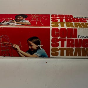 May include: A rectangular Parker Brothers Construct-O-Straws toy box with a red and white design. The box features illustrations of children building structures with straws and the text CONSTRUCT-O-STRAWS printed in large bold lettering.