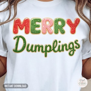 以下が含まれることがあります： グリッター調のマルチカラーフォントで「Merry Dumplings」と書かれた白いTシャツ。Merryの文字は赤、緑、ピンクで、Dumplingsの文字は緑色です。各文字にはゴールドの縁取りが施され、光沢のある3D効果が表現されています。