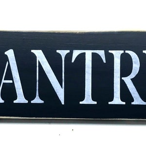 May include: Black wooden sign with white lettering that reads "PANTRY".