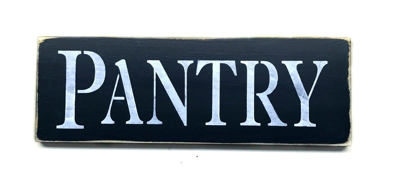 May include: Black wooden sign with white lettering that reads "PANTRY".