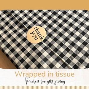 May include: Black and white checkered tissue paper with a gold "thank you" sticker with a heart.