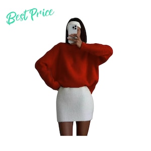 Può includere: Un maglione rosso brillante a maniche lunghe con una consistenza soffice abbinato a una minigonna bianca a coste. Il testo "Best Price" appare in verde chiaro nell'angolo in alto a sinistra. L'outfit è indossato con una fascia bianca e uno smartphone.