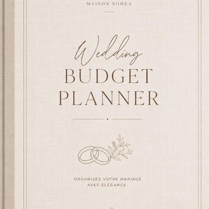 Peut inclure: Un planificateur de budget de mariage à couverture en tissu beige avec du texte brun foncé indiquant Maison Sohéa, Wedding Budget Planner et Organisez votre mariage avec élégance. La couverture présente une illustration au trait de deux alliances.
