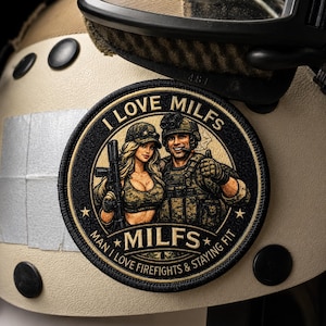 Könnte beinhalten: Ein runder bestickter Aufnäher mit einem Soldaten und einer Frau in Tarnkleidung, die beide Gewehre halten. Der Text lautet oben I LOVE MILFS und unten MAN I LOVE FIREFIGHTS & STAYING FIT, wobei MILFS im unteren Bereich zentriert ist.