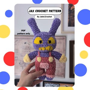 Puede incluir: Un peluche de ganchillo morado con orejas largas, ojos amarillos y boca amarilla. La figura lleva un peto rosa con botones amarillos y puños de color amarillo claro. El texto superior dice JAX CROCHET PATTERN By Jaimi.Crochet, PDF pattern only.