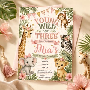 Op de afbeelding: Een rechthoekige verjaardagsuitnodigingskaart met de tekst Young Wild and Three Come Celebrate Mia's 3rd Birthday Adventure. Het ontwerp bevat illustraties van een giraffe, aap, zebra, olifant en leeuwenwelp omringd door tropische bladeren en roze bloemen met gouden vlaggetjes.