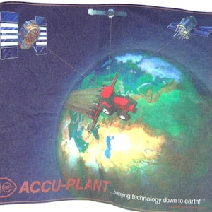 Peut inclure: Une bannière rectangulaire en tissu bleu foncé avec un graphique de la Terre surmonté d'un tracteur rouge. Trois satellites orbitent autour de la planète, reliés par de fines lignes. Le texte indique ACCU-PLANT ...bringing technology down to earth!