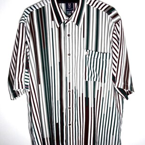 May include: A short-sleeved button-down shirt featuring a vertical striped pattern in shades of dark green, maroon, gray, and white. The shirt includes a pointed collar, a front button placket, and a single chest pocket on the left side.